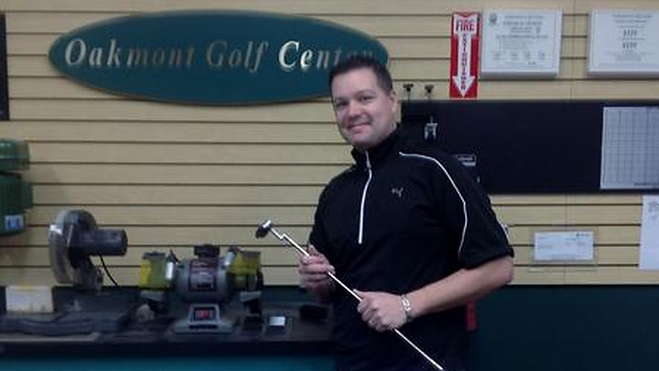 Dave Gedris, PGA Professional, holding a club at the counter of Oakmont Golf Center