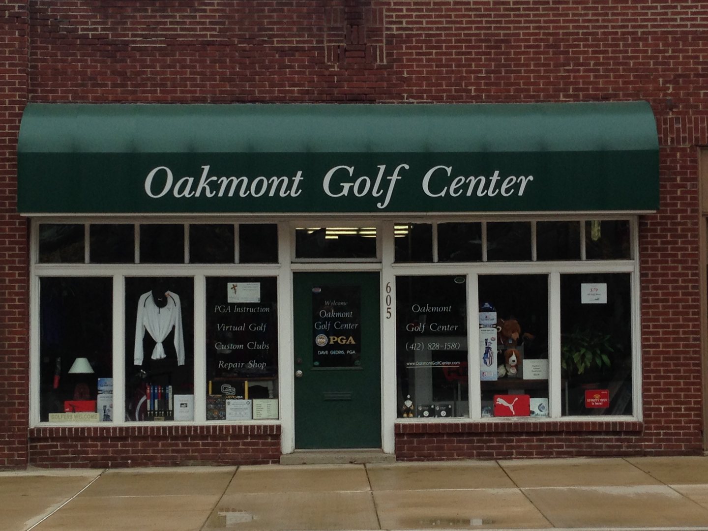The green awning and brick storefront of Oakmont Golf Center at 605 Allegheny Avenue